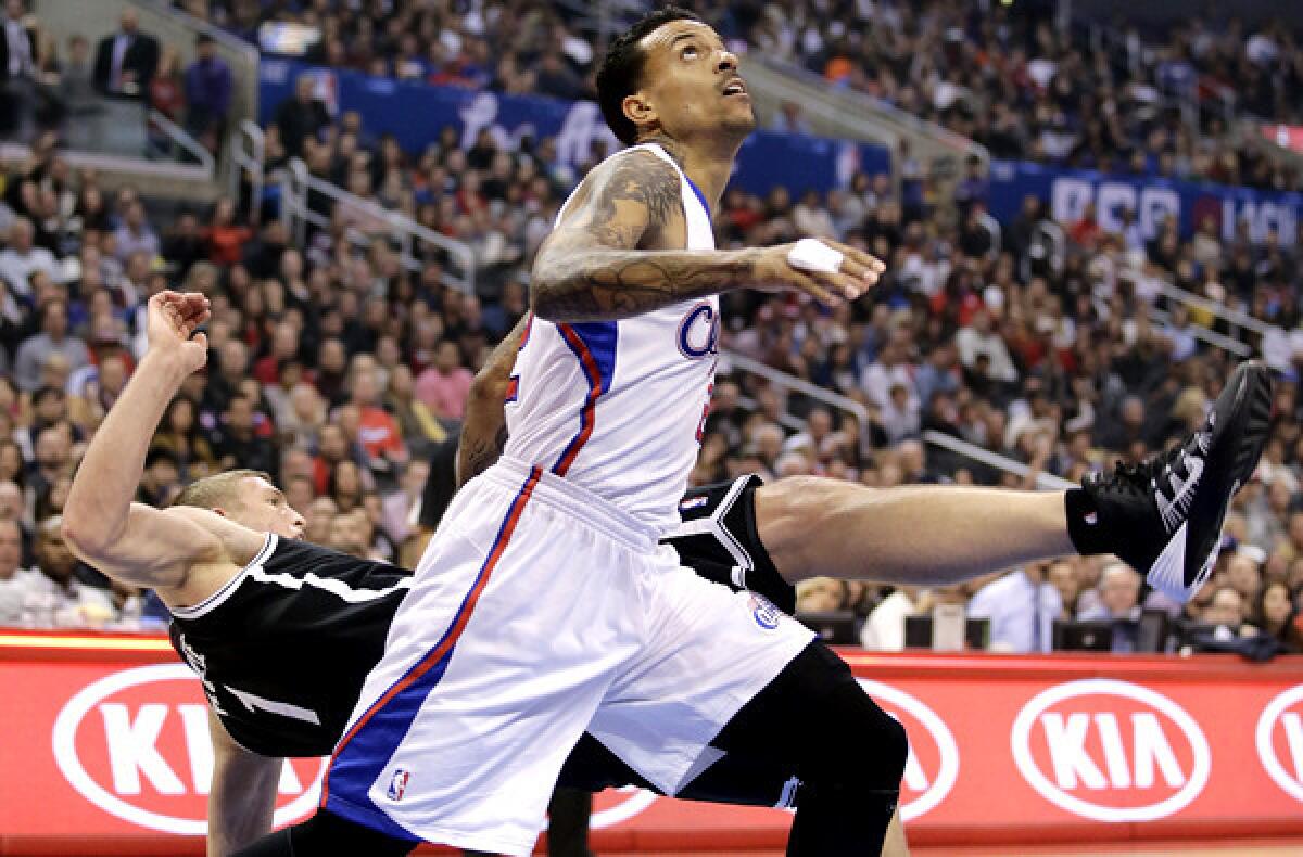 Clippers forward Matt Barnes sends Nets forward Mason Plumlee to the court during a battle for rebounding position in a game Saturday at Staples Center. Barnes was called for a foul on the play.
