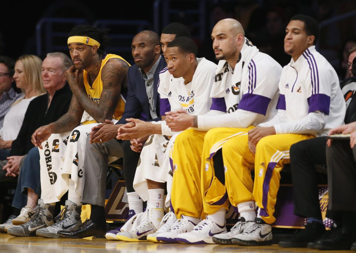 Kobe Bryant sits with his Lakers teammates on the bench during the first half of a game Tuesday against the Detroit Pistons at Staples Center.