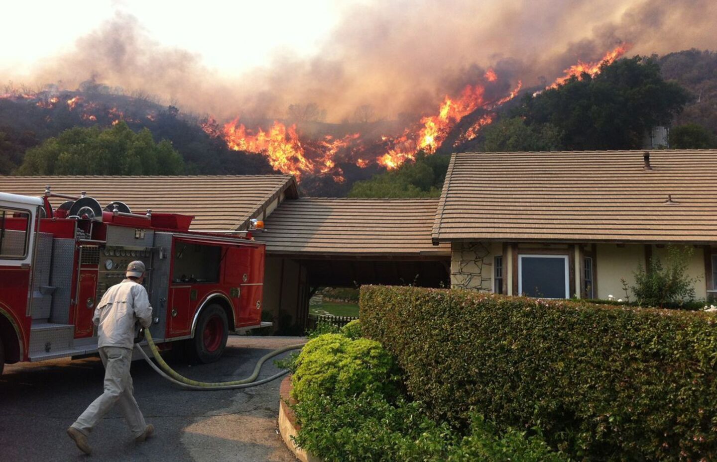 Flames from the Springs fire threaten homes in Thousand Oaks on Friday.