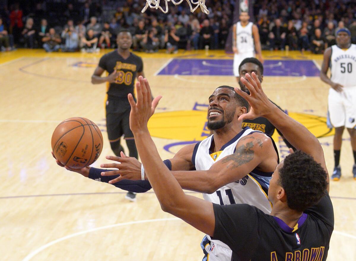 Grizzlies guard Mike Conley, left, shoots as Lakers forward Anthony Brown defends during the first half of a game on Feb. 26.