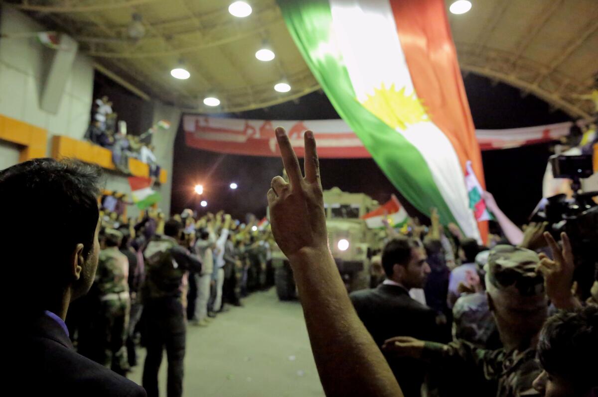 Thousands of ethnic Kurds cheer for Iraqi Kurdish forces as they cross the border into Turkey on their way to the Syrian town of Kobani on Oct. 29.