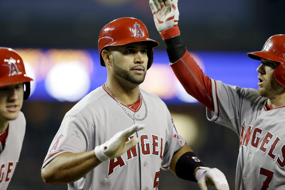 Angels first baseman Albert Pujols is congratulated by teammates after hitting a three-run home run -- the 497th homer of his career -- on Friday night in Detroit.