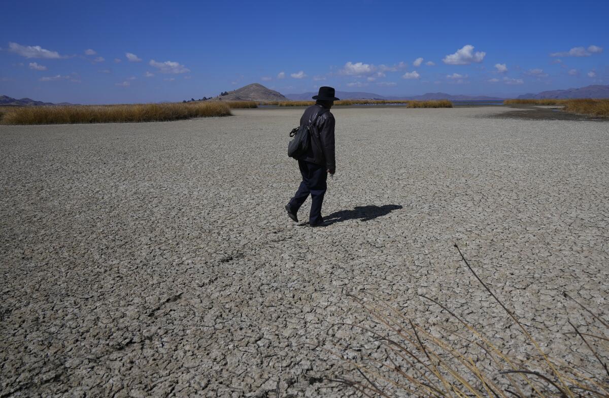 An Aymara man walks on the dry cracked bed of Lake Titicaca.