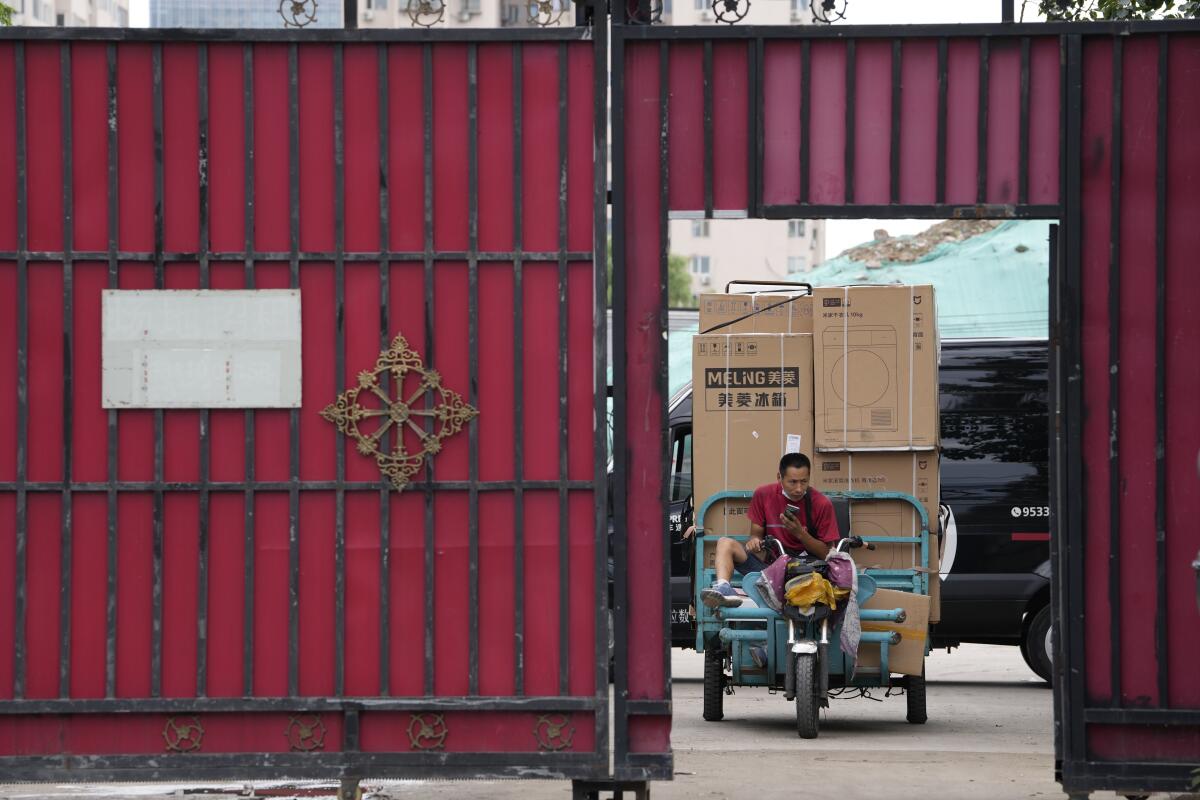 Un hombre transporte productos en Beijing el 15 de agosto del 2022. (Foto AP/Ng Han Guan)