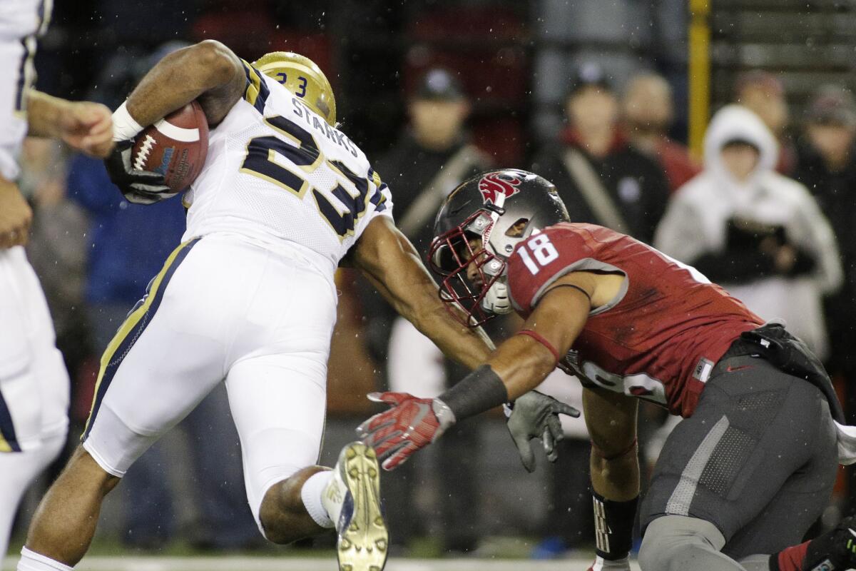 UCLA running back Nate Starks tries to get away from Washington State safety Shalom Luani during the first half of a game on Oct. 15.