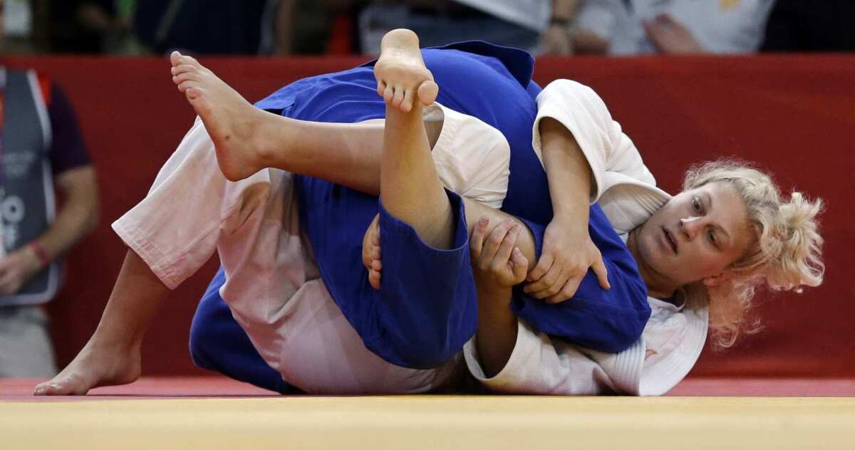 Kayla Harrison, in white, competes against Hungary's Abigel Joo in the 2012 Summer Olympics in London.