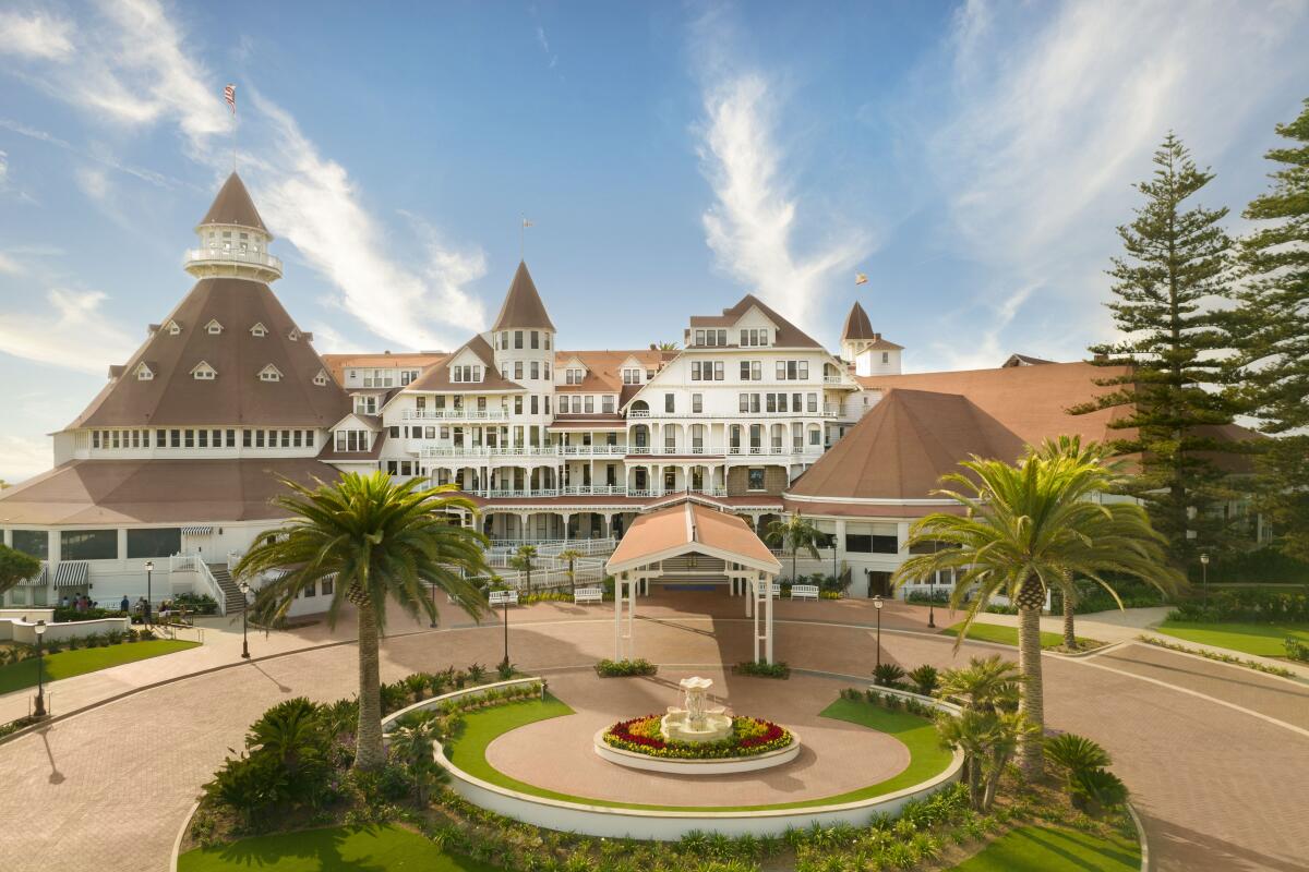 Exterior of the Hotel del Coronado, fronted by a large oval lawn with palm trees