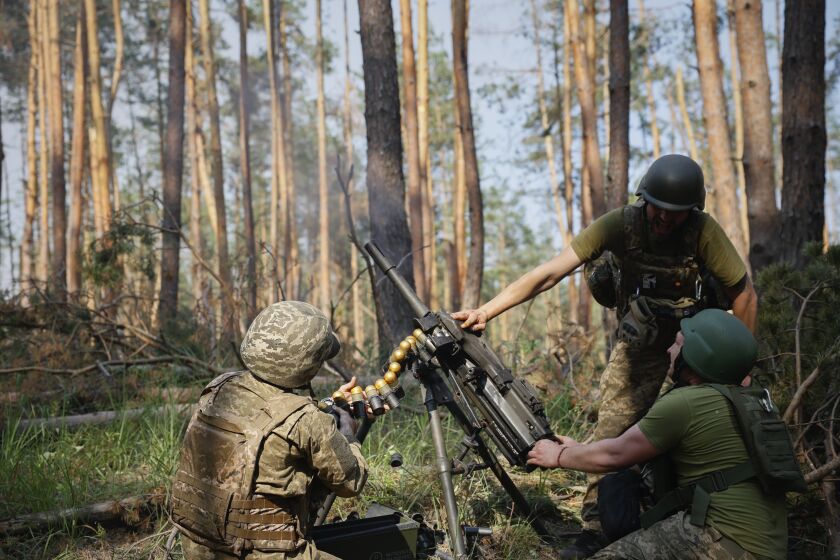 Ukrainian soldiers fire the grenade launcher towards the Russian positions on the frontline near Kreminna, Luhansk region, Ukraine, Thursday, June 8, 2023. (Roman Chop via AP)