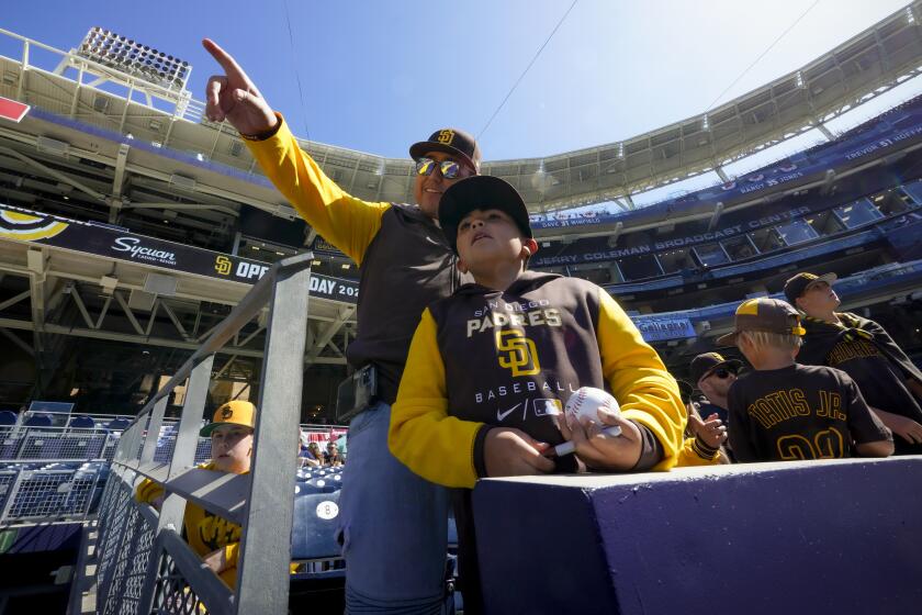 San Diego, CA - April 14: Jonathan Marquez from Scripps Ranch and his son Jonathan Marquez, Jr. wait near the Padres dugout at Petco Park hoping for the chance to get a player autograph on the Padres home opening day on Thursday, April 14, 2022 in San Diego, CA. against the Atlanta Braves. (Nelvin C. Cepeda / The San Diego Union-Tribune)