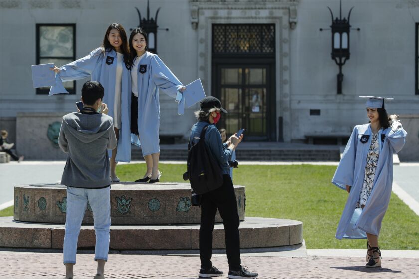 Estudiantes de la Universidad de Columbia posan para fotografías el día de la graduación, el 20 de mayo de 2020, en Nueva York. (AP Foto/Frank Franklin II, Archivo)