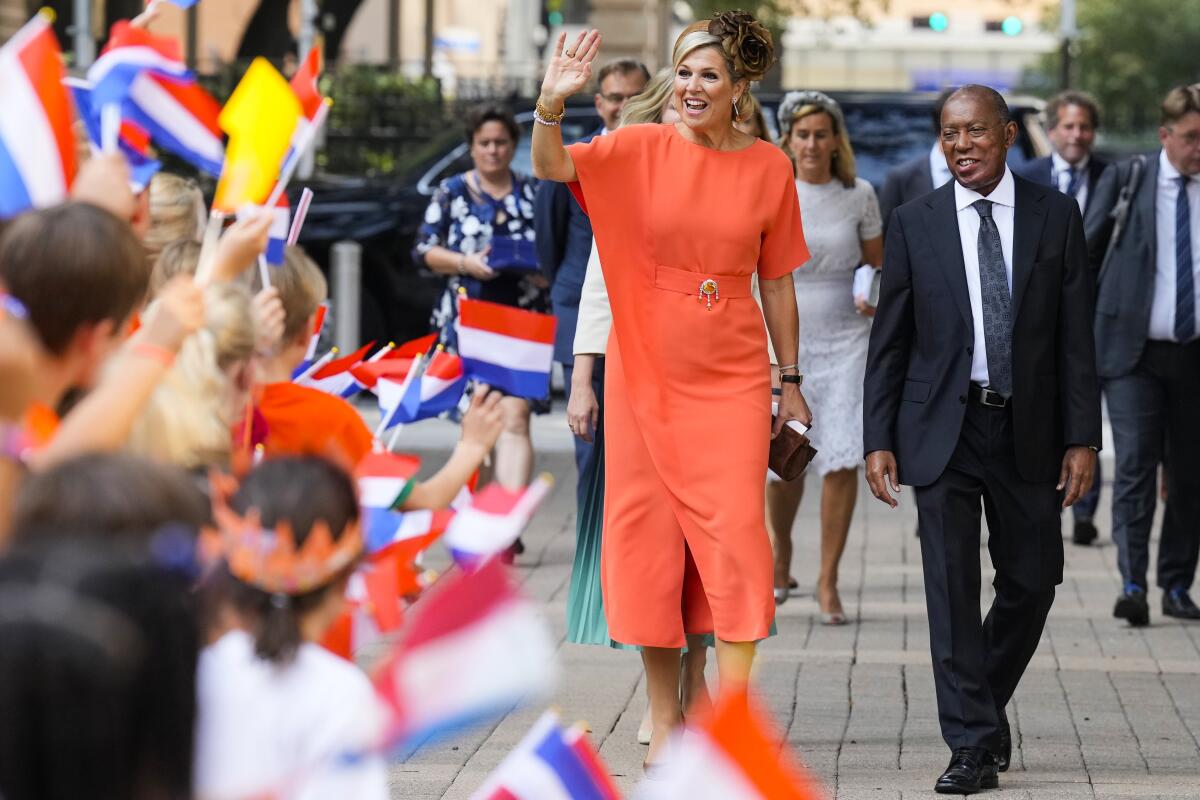 Queen Maxima, of the Netherlands, waves to a gathering of school children as she walks with Houston Mayor Sylvester Turner as she arrives at City Hall on Friday, Sept. 9, 2022, in Houston. (Brett Coomer/Houston Chronicle via AP)
