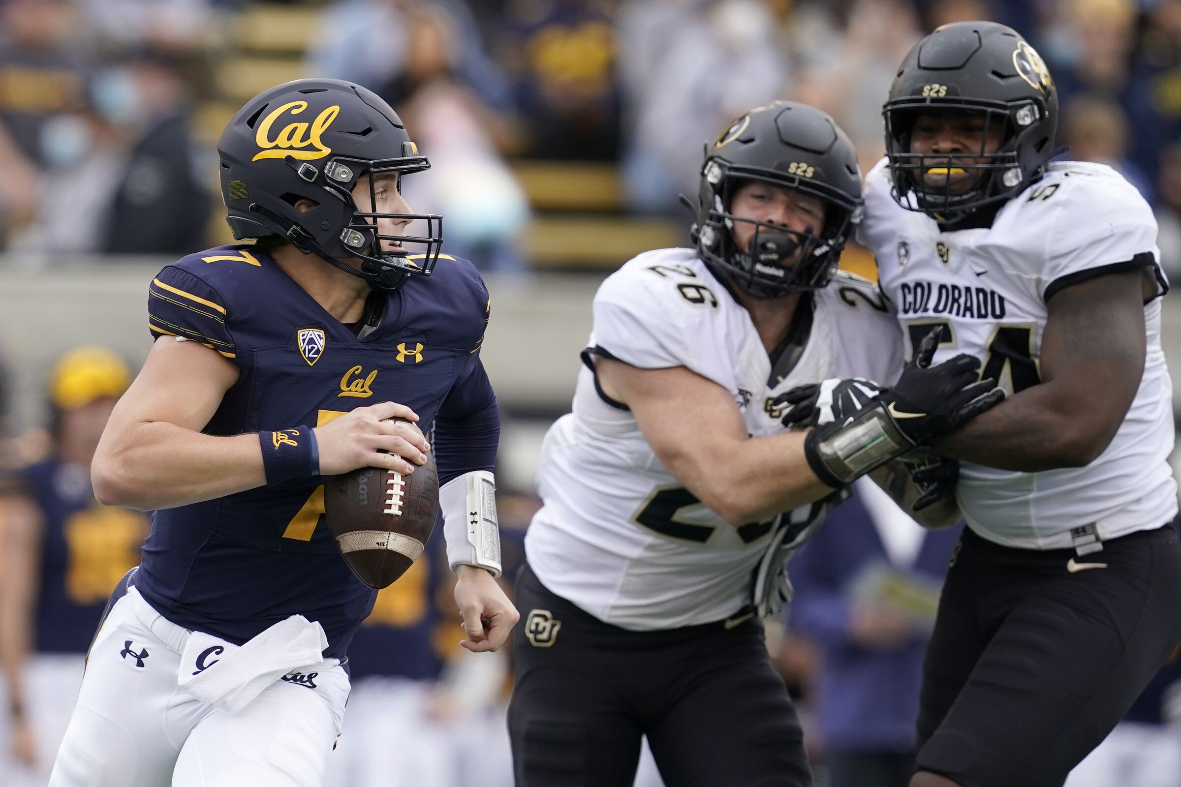 California quarterback Chase Garbers scrambles away from Colorado's Carson Wells (26) and Terrance Lang.