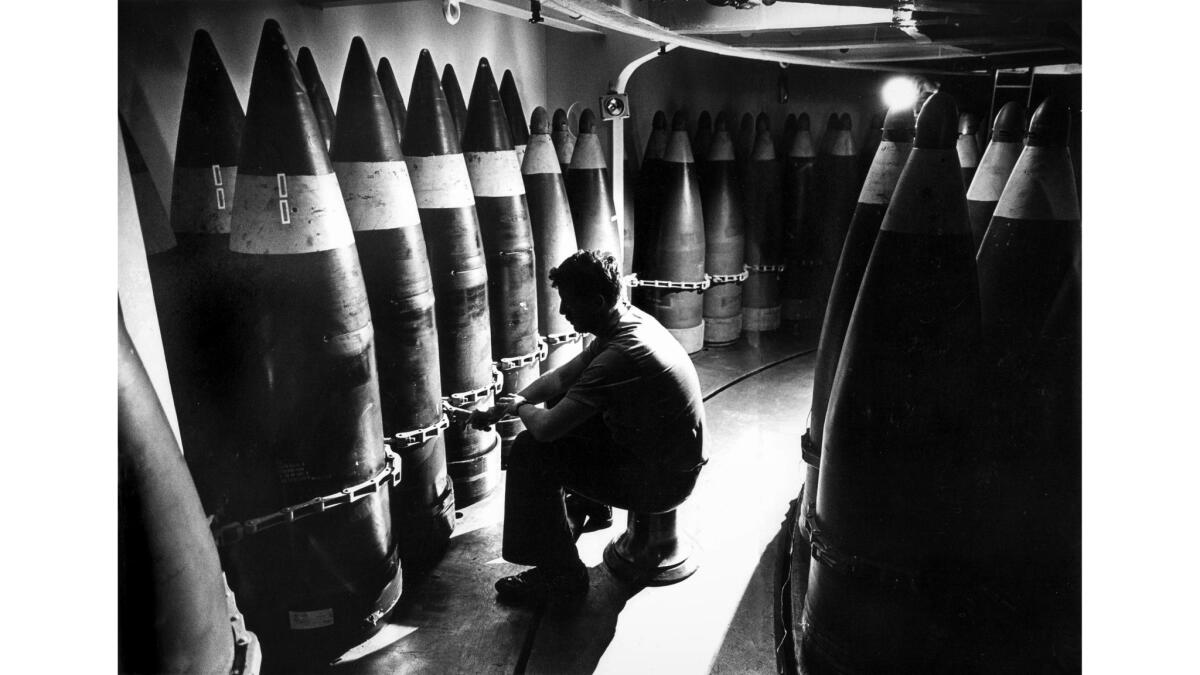 July 2, 1987: Gunner's mate Bill Allen does maintenance on 16-inch shells, deep inside the Missouri. Many of the shells weigh over 2,000 pounds. This photo appeared in the July 6, 1987, Los Angeles Times.