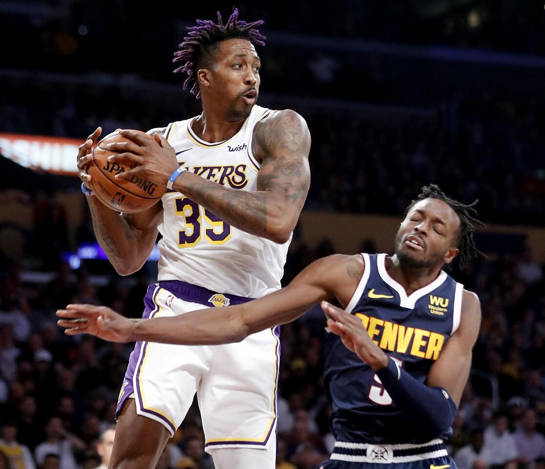 Lakers center Dwight Howard pulls a rebound away from Nuggets forward Jerami Grant.