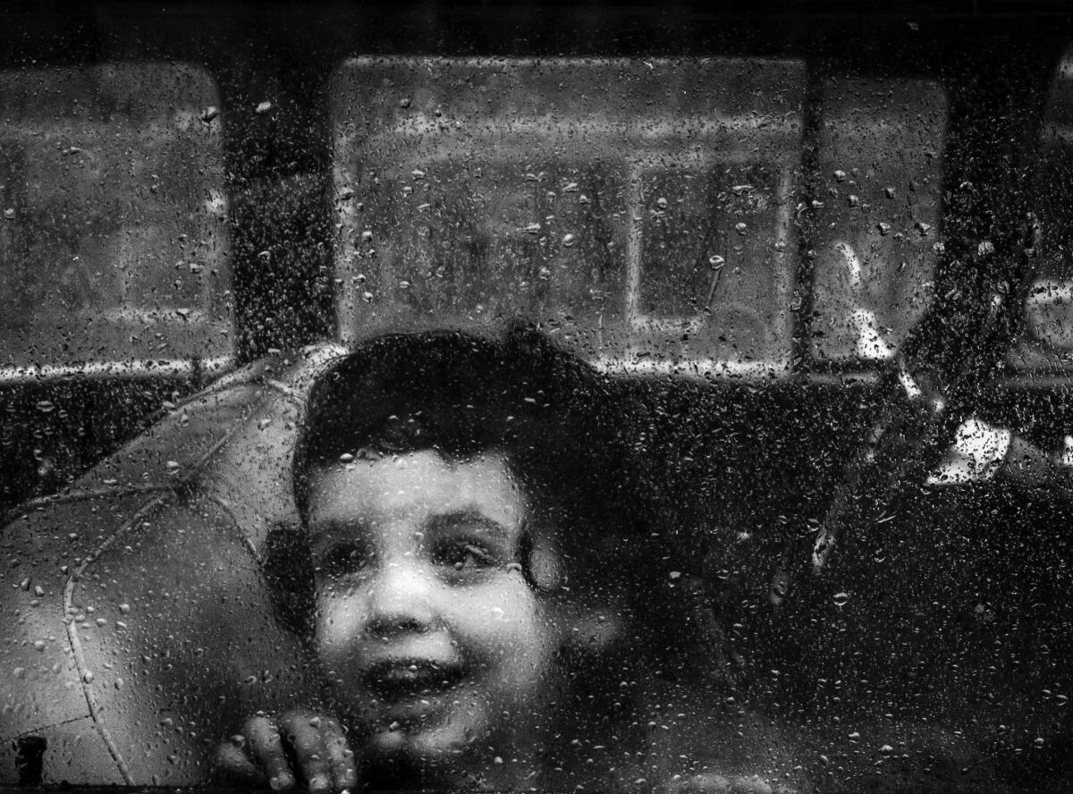 A little girl peers out of a car window during a 1963 rain storm in the San Fernando Valley.
