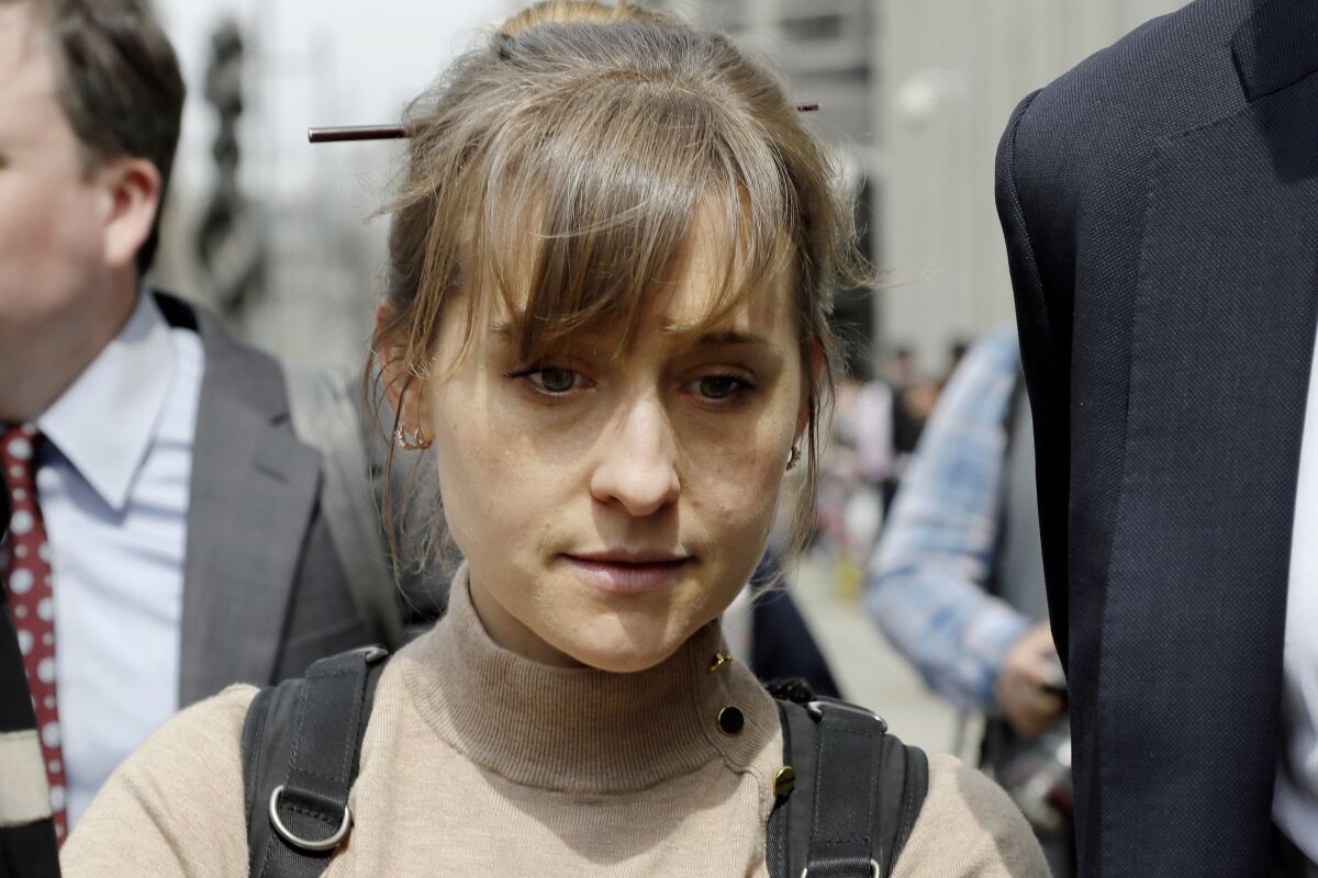 FILE- In this April 8, 2019 file photo, actor Allison Mack leaves Brooklyn federal court in New York after pleading guilty to racketeering charges in a case involving a cult-like group based in upstate New York called NXIVM. Mack, who played a key role in the cultlike group NXIVM, has surrendered to a California prison to serve her sentence in a New York case against the group’s spiritual leader. (AP Photo/Mark Lennihan, File)
