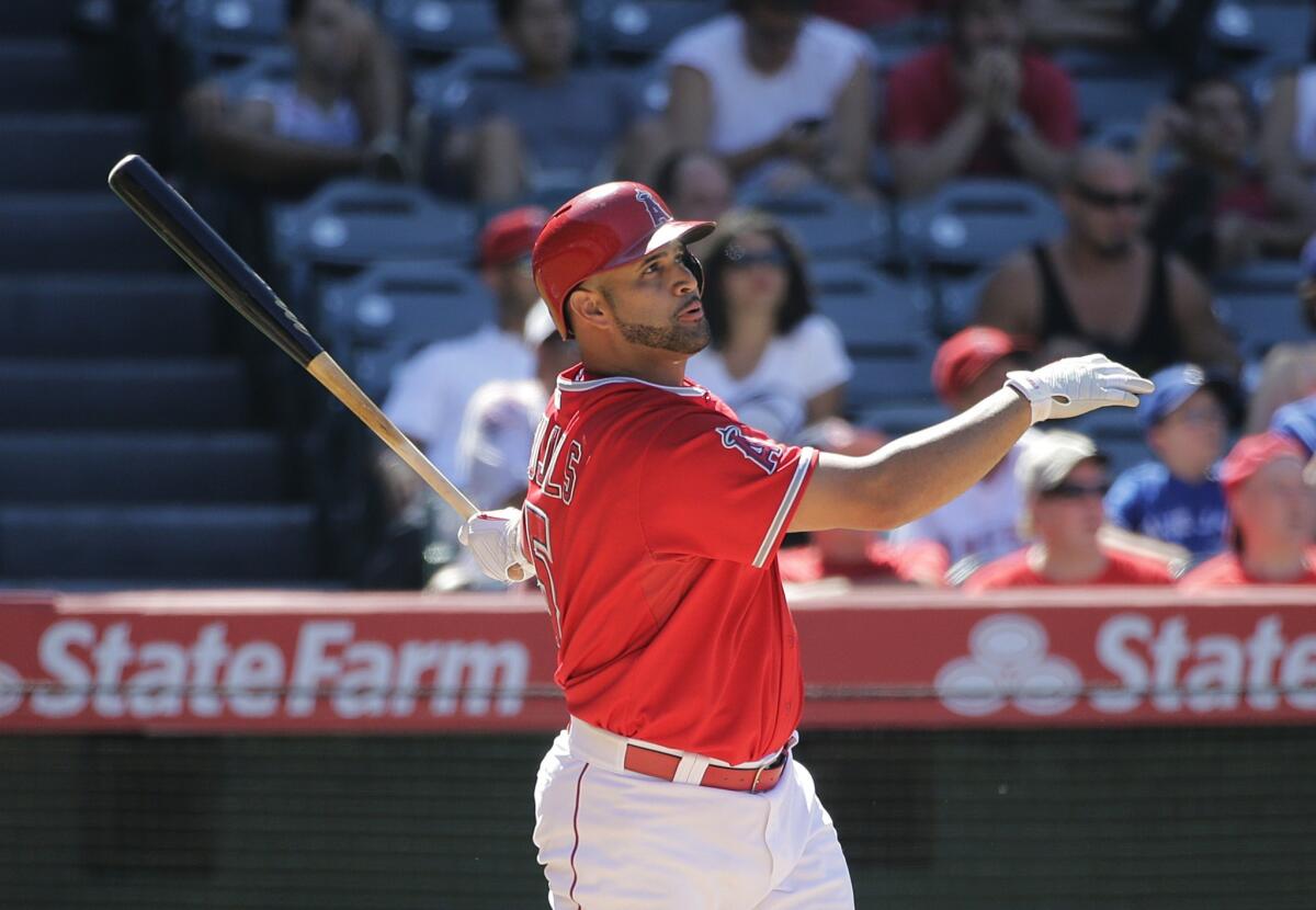 Albert Pujols watches the flight of his two-run home run in the seventh inning of the Angels' 8-7 win Wednesday over the Toronto Blue Jays at Angel Stadium.