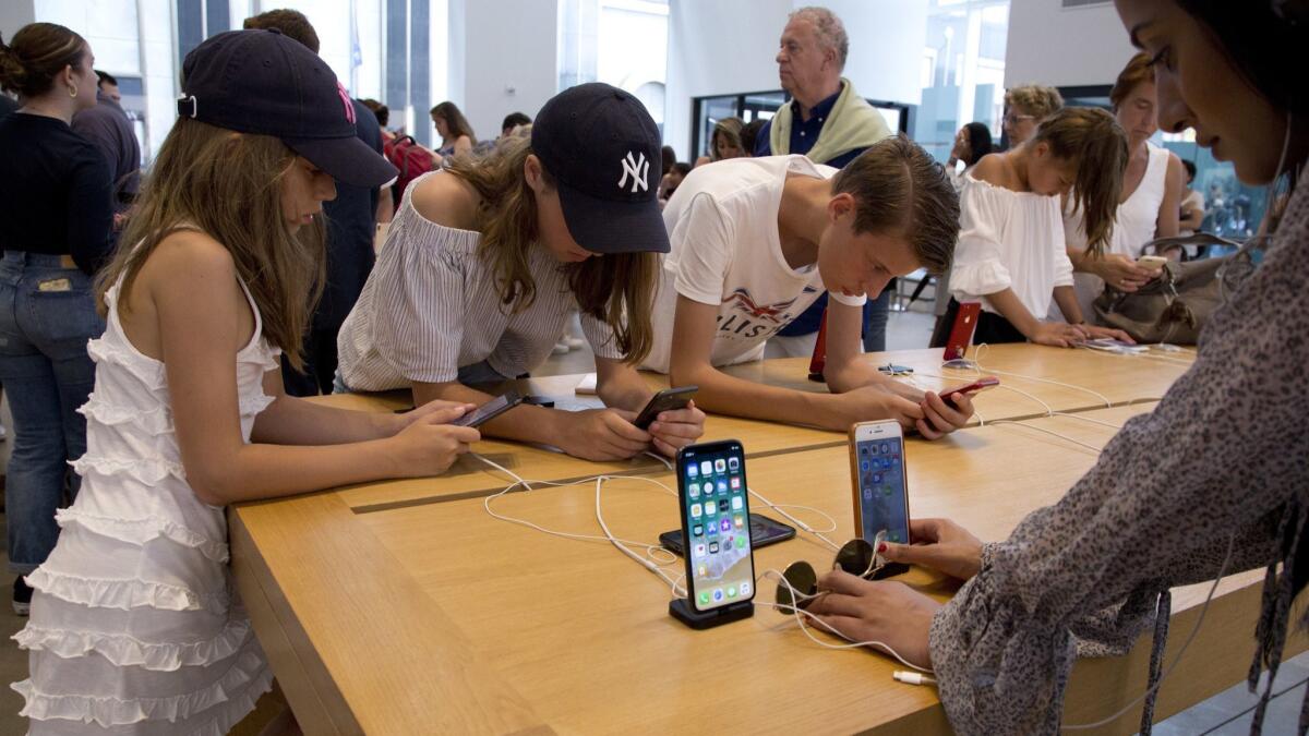 Customers shop in an Apple store in New York in August. Apple is expected to announce a host of new products this week, including three new iPhone models.