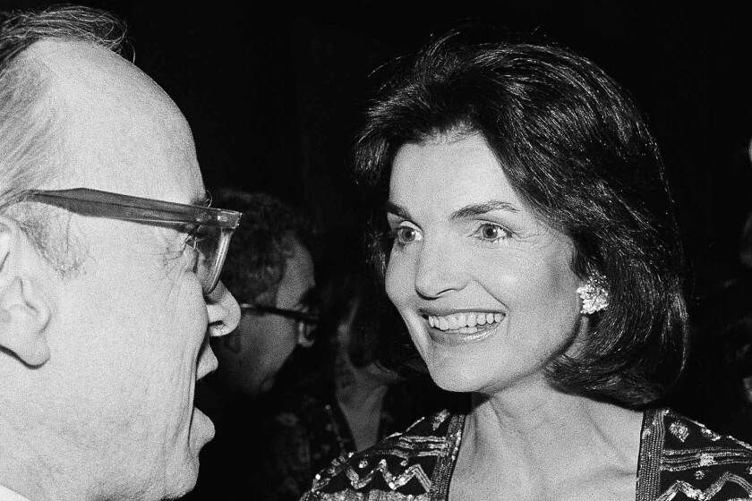 Arthur Schlesinger Jr. and Jacqueline Kennedy Onassis speak at a publishing party in New York City, in 1978.