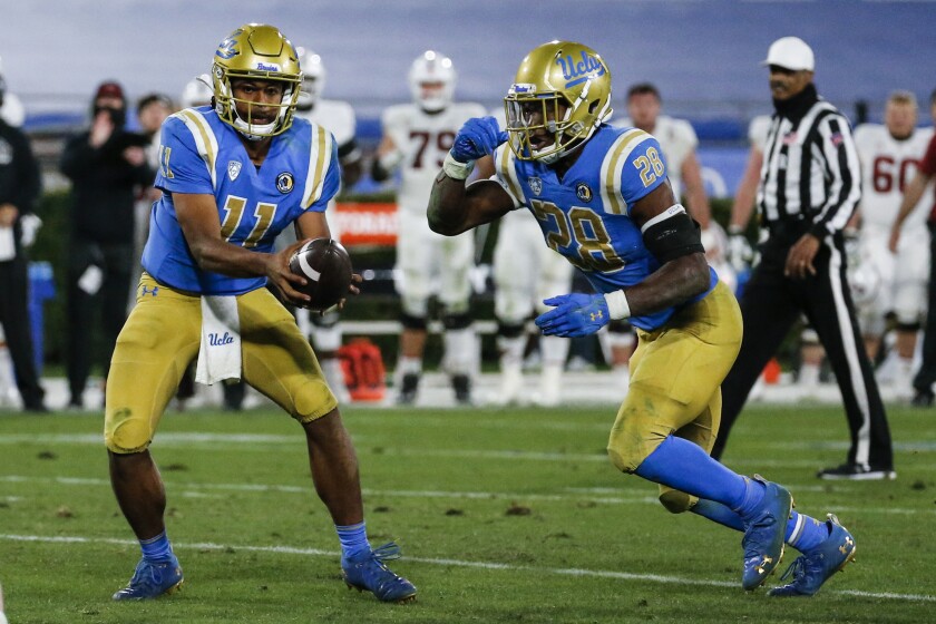 UCLA quarterback Chase Griffin hands off the ball to UCLA running back Brittain Brown.