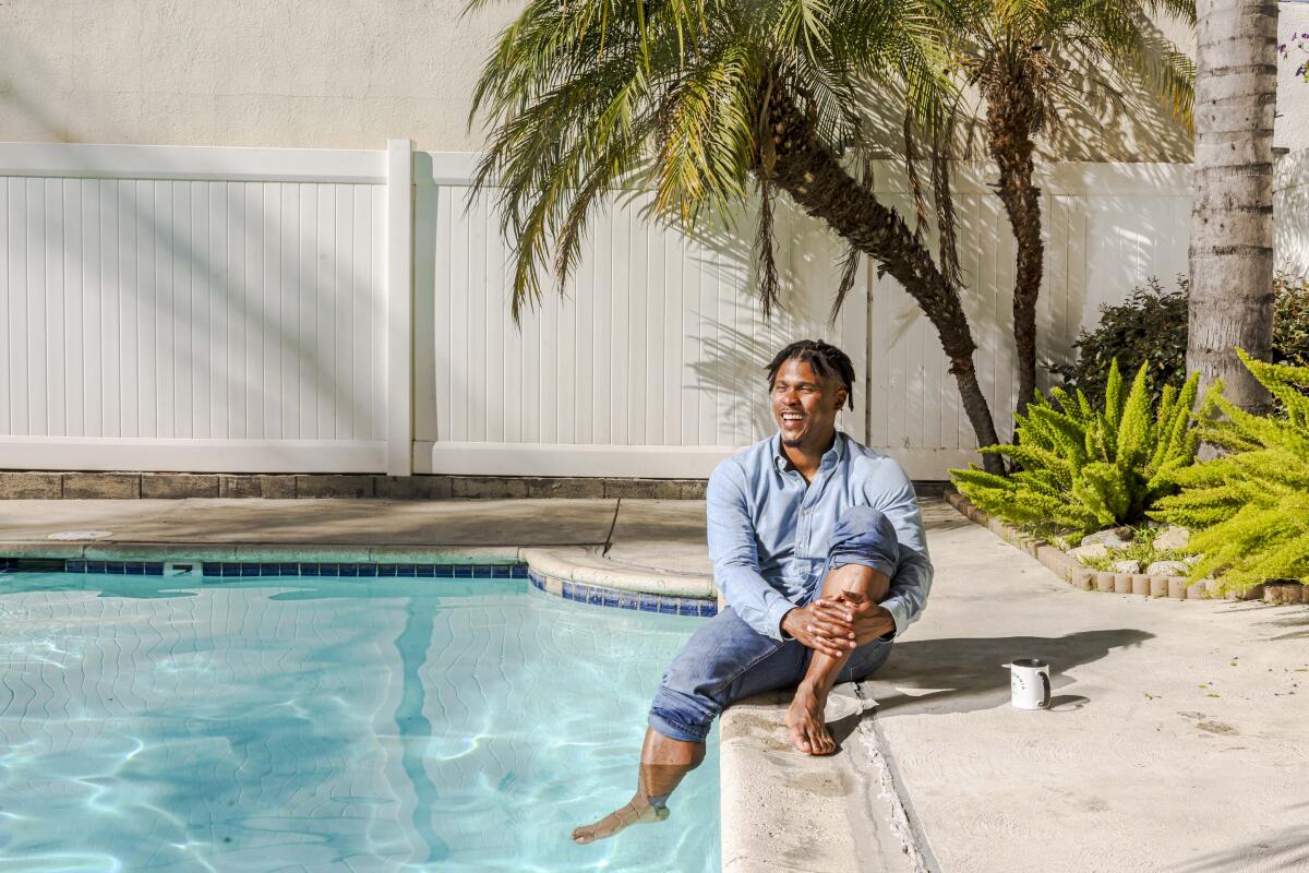 A man sits with one leg in a swimming pool