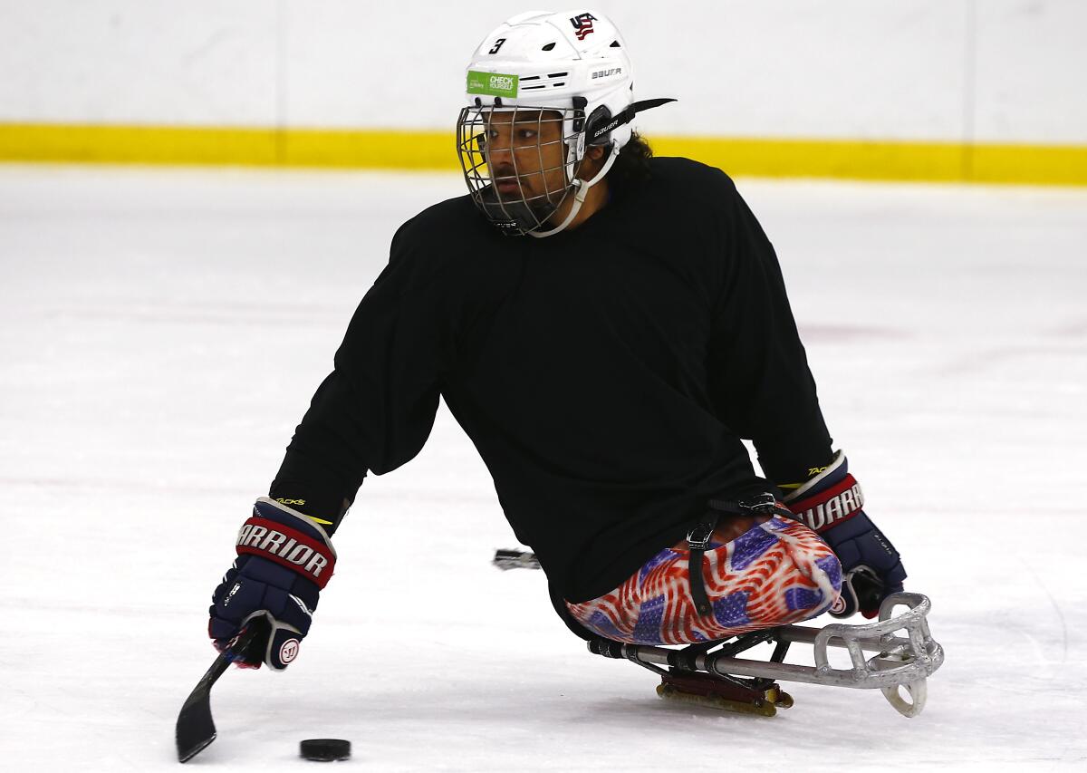 Ralph DeQuebec, a Paralympic hockey gold medalist from Harbor City, participates in a sled hockey clinicat Great Park Ice rinks in Irvine on Saturday.