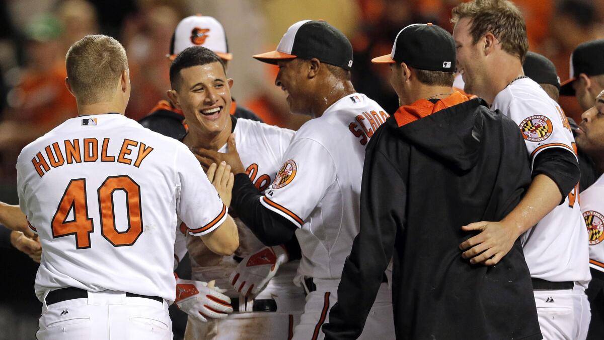 Baltimore's Manny Machado, second left, celebrates with teammates after hitting a walk-off home run in the 12th inning of a 7-6 win over the Angels on Tuesday.