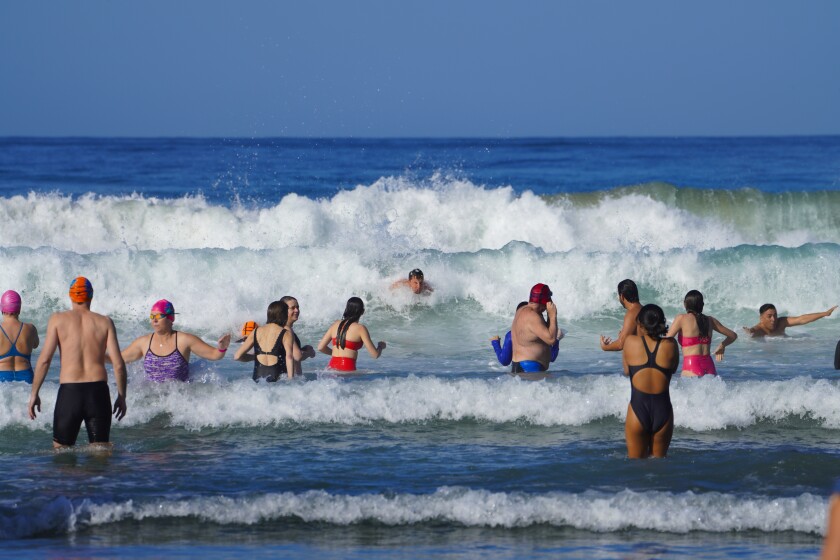 Swimmers brave chilly surf at La Jolla Shores on Saturday during the annual Polar Bear Plunge to ring in the new year.