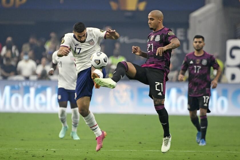 United States midfielder Sebastian Lletget (17) and Mexico defender Luis Rodriguez battle for the ball during the first half of the CONCACAF Gold Cup final soccer match, Sunday, Aug. 1, 2021, in Las Vegas. (AP Photo/David Becker)