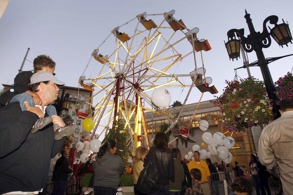 Shoppers stroll past the first-ever Ferris wheel on Rodeo Drive in Beverly Hills during Fashion's Night Out.