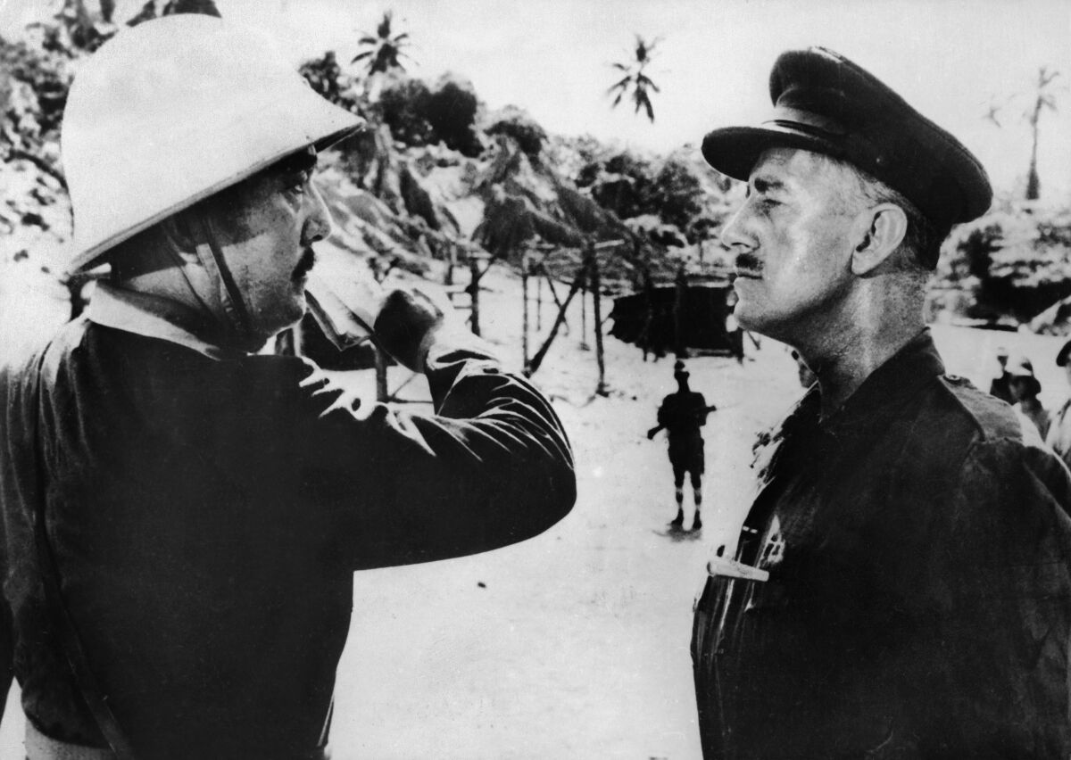 A black-and-white film still of two soldiers facing one another