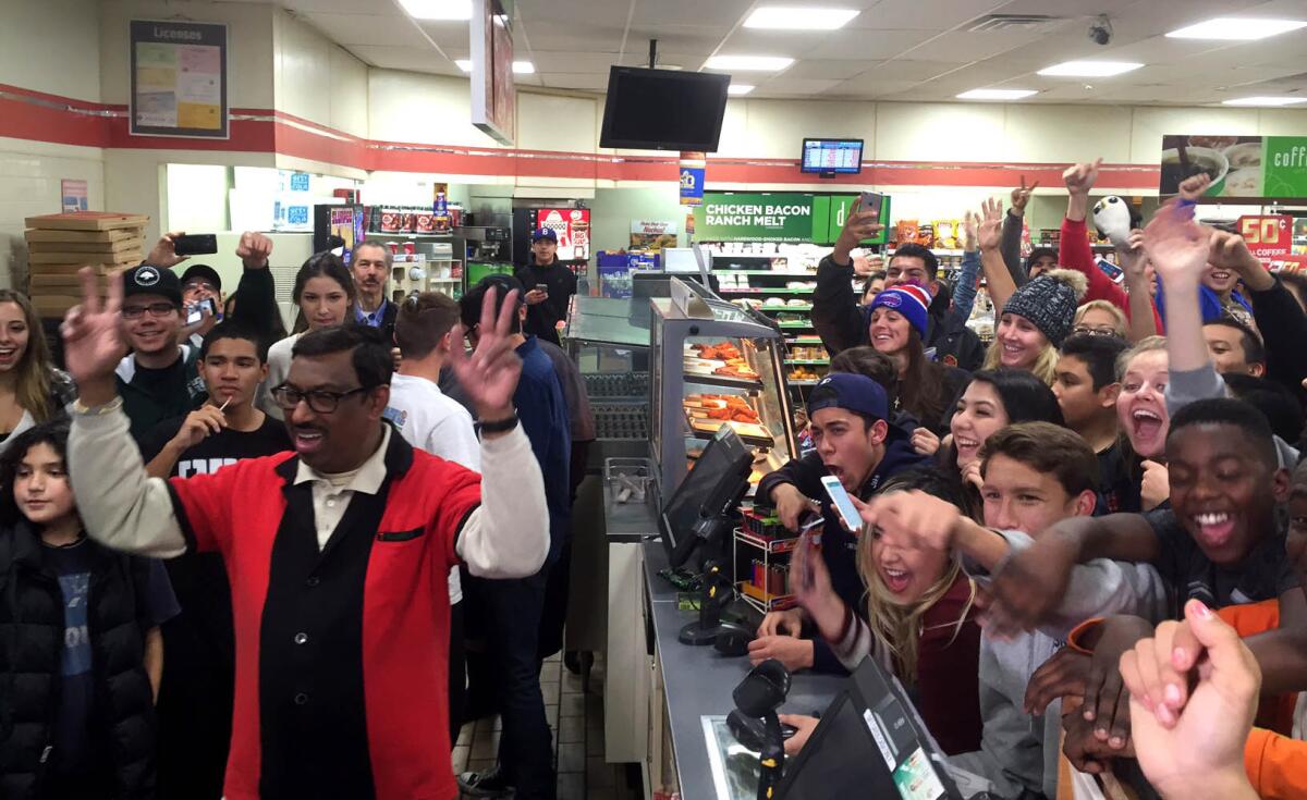 M. Faroqui, left, celebrates the sale of a winning Powerball ticket at a 7-Eleven in Chino Hills.