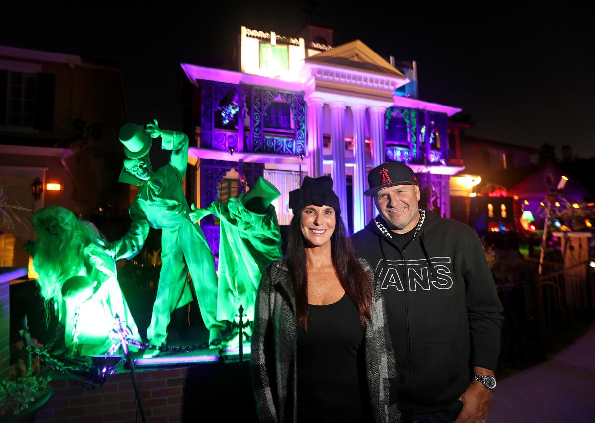 Dawn and Mike Stanley stand in front of their home designed and decorated for Halloween in Alison Viejo.