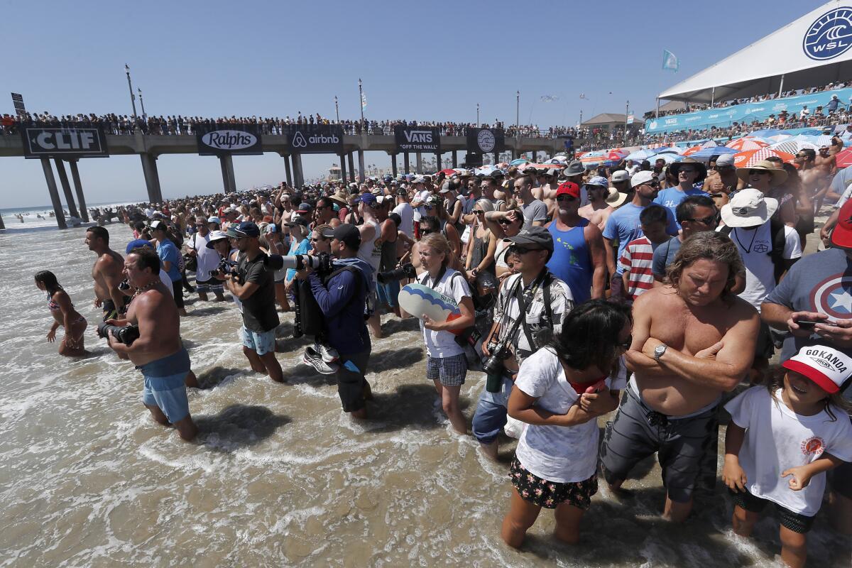 HUNTINGTON BEACH, CALIF. - AUG. 5, 2018. Fans stand at the water's edge during the finals of the 2018 Vans U.S, Open of Surfing on Sunday, Aug. 5, 2018, in Huntington Beach. (Luis Sinco/Los Angeles Times)