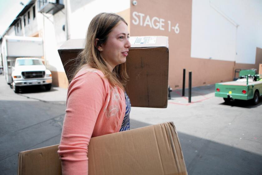 "Witches of East End" production assistant Amy Thurlow carries boxes from the mailroom at Sunset Bronson Studios in Hollywood.