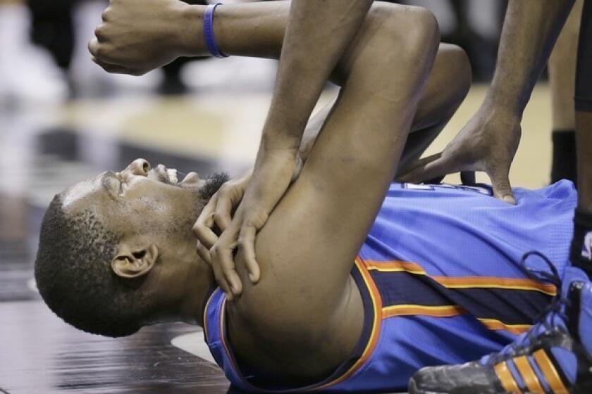 Kevin Durant grimaces after he was fouled trying to dunk against the Spurs on Wednesday night in San Antonio.