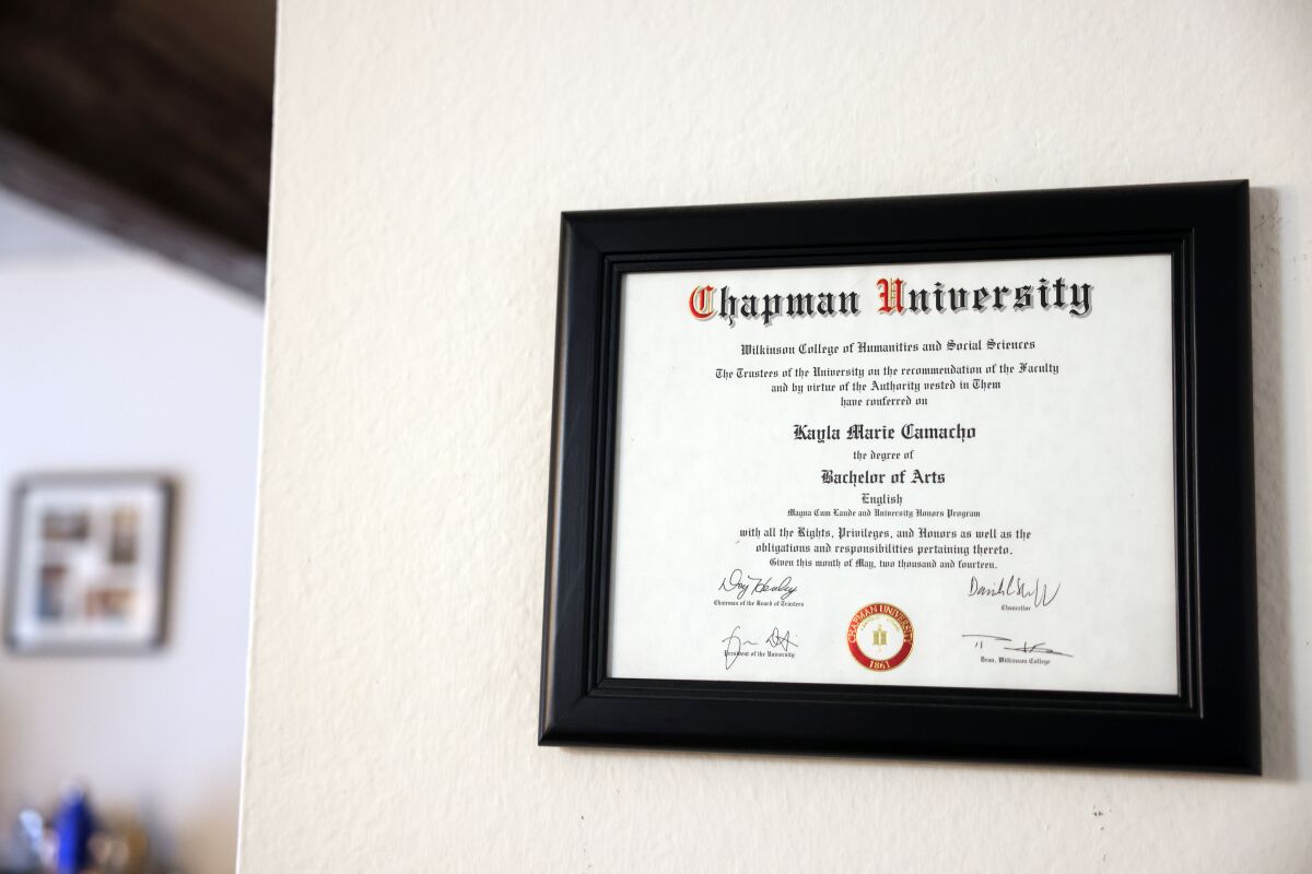 Kayla Camacho's college degree from Chapman University hanging on a wall.