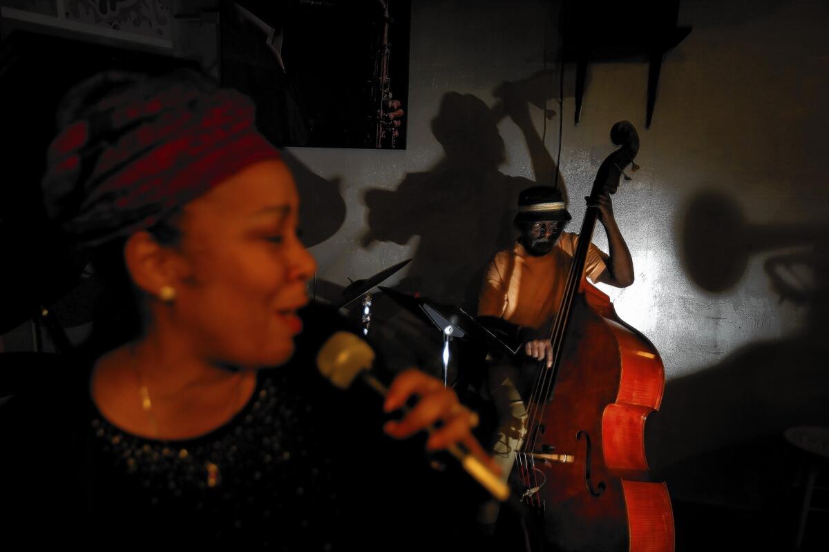 Bob Lee, 64, plays the upright bass while Ellen Cooper, 54, belts out a tune at the World Stage in Leimert Park Village on Thursday.