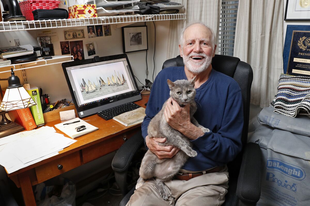 Longtime Newport Beach resident and photographer Jim Fournier, 80, poses with his 15-year-old cat at their home. An exhibit of Fournier's work is on display at the Balboa Island Museum.