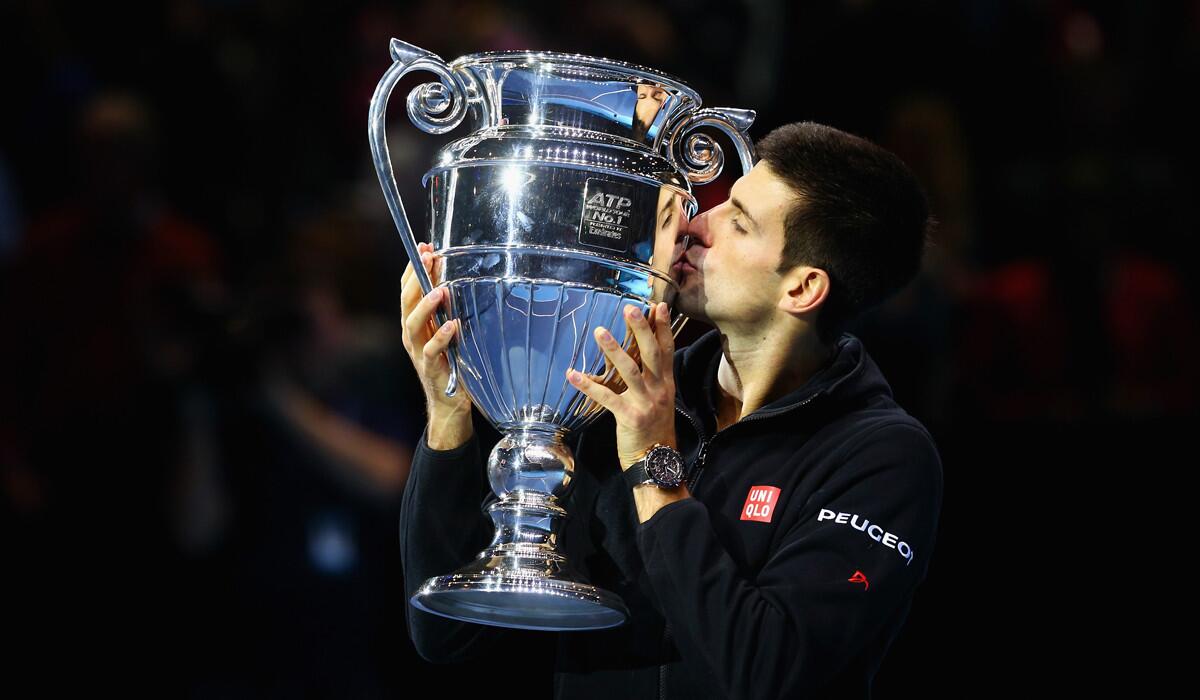 Novak Djokovic kisses the Barclays ATP World Tour No. 1 Award trophy after defeating Tomas Berdych on Friday to advance to the semifinals of the ATP Finals.