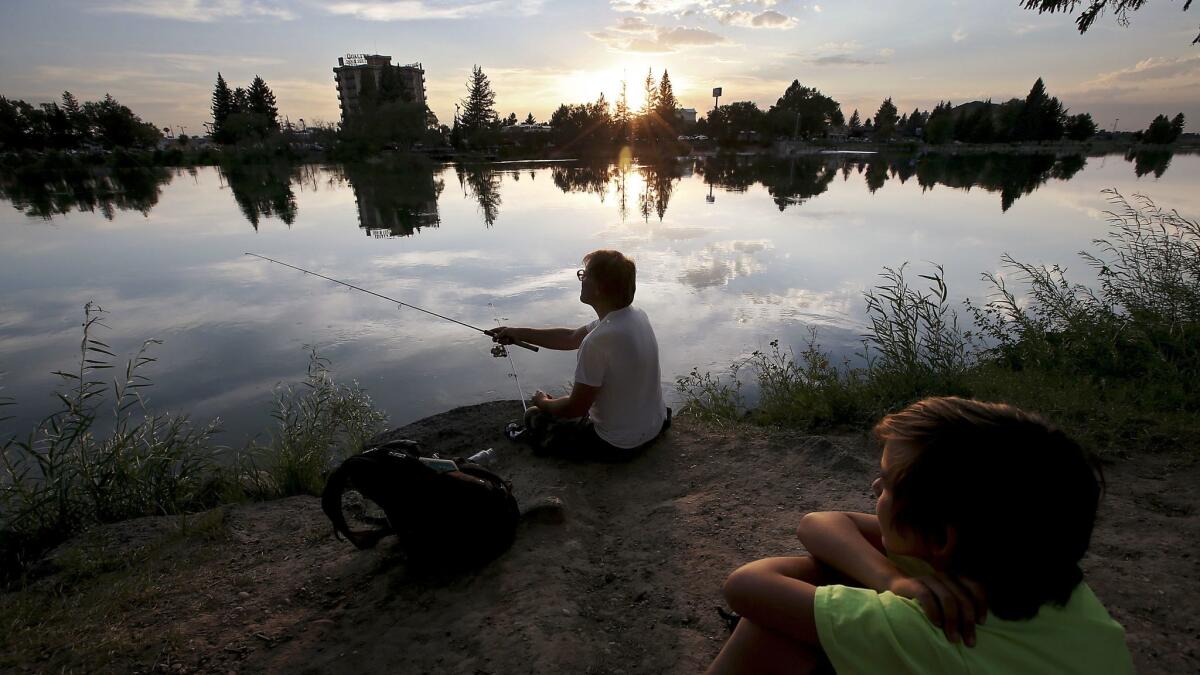James Hathaway and his son Alex, 9, fish on the banks of the Snake River in Idaho Falls.