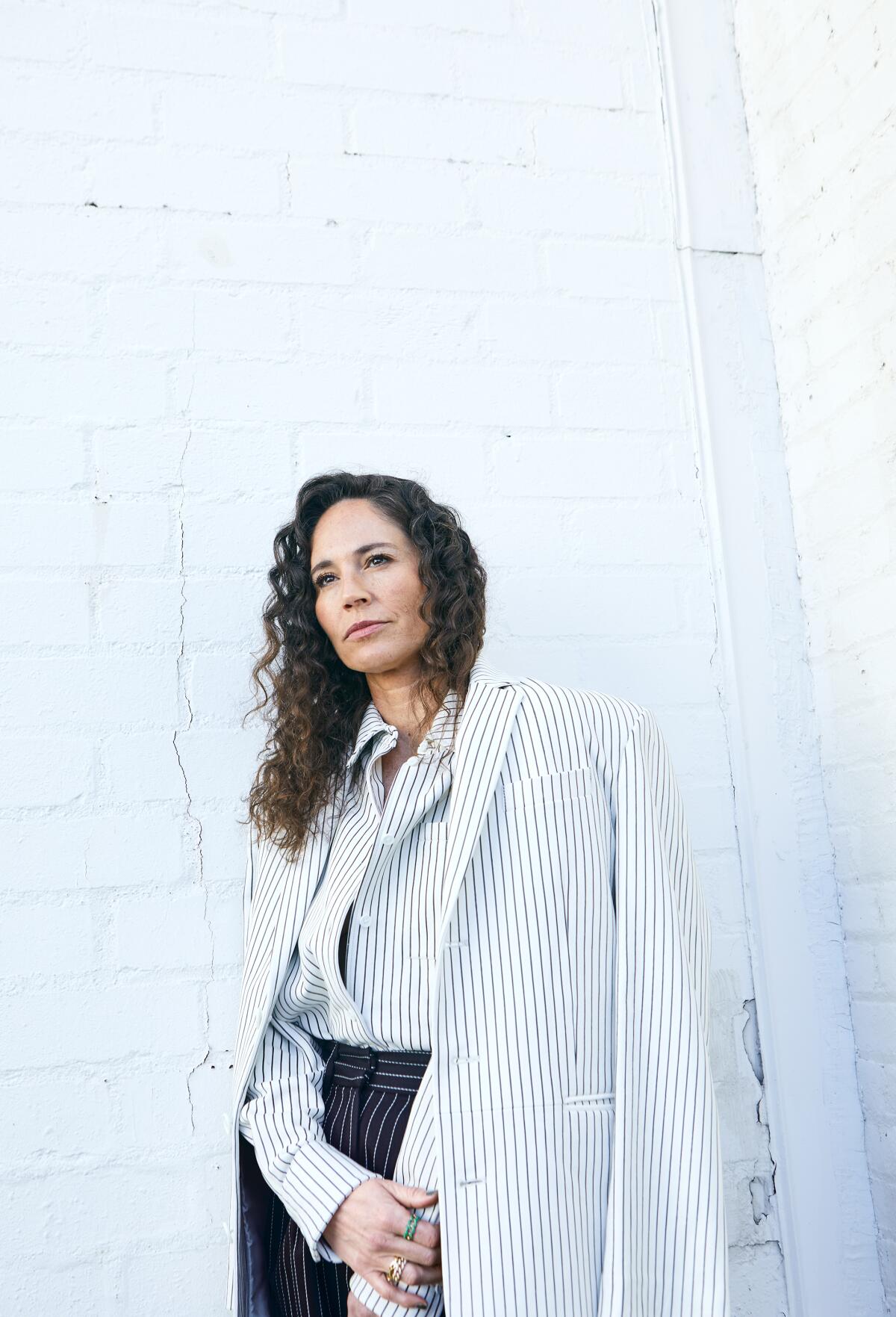 Sue Bird poses in front of a white brick wall