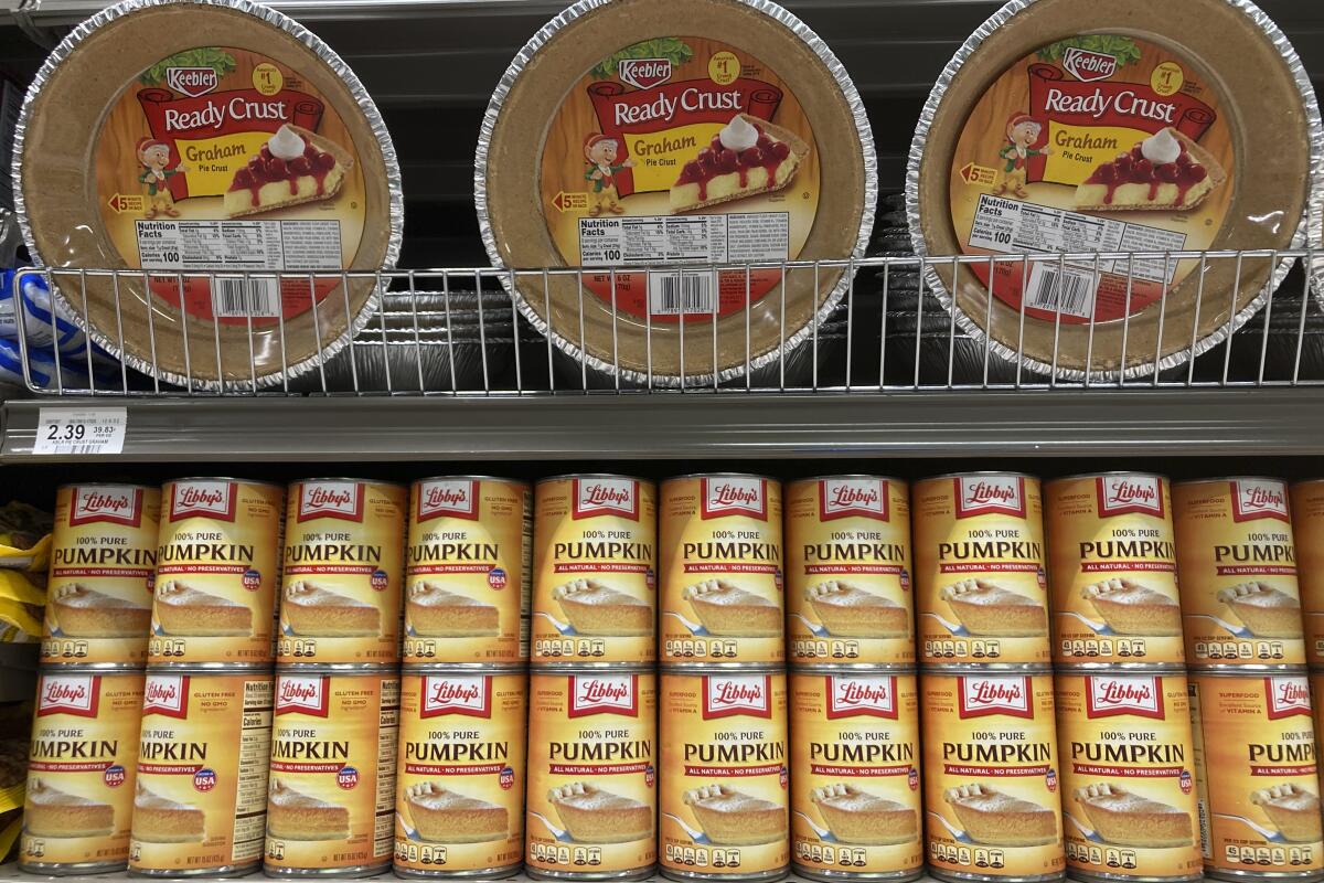 Canned pumpkin and graham cracker shell crusts in a supermarket.
