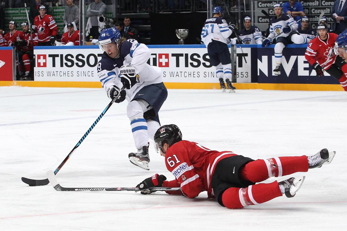 Finland's Patrik Laine plays the puck against Canada's Mark Stone.