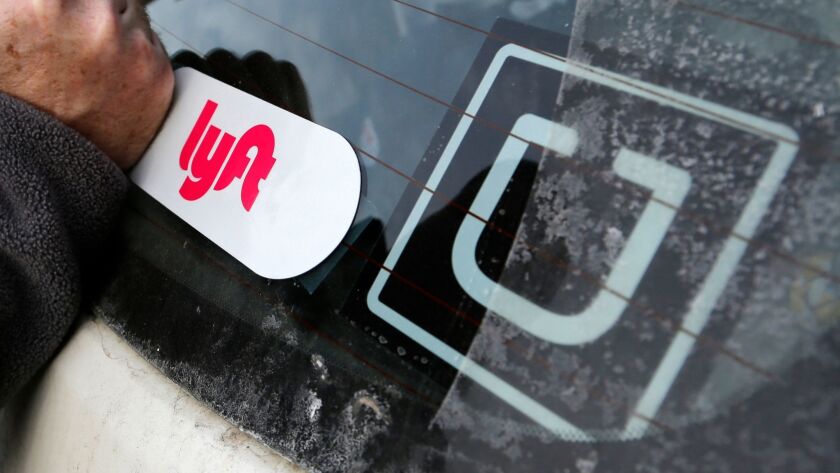 Logos on a car indicate it gives rides through both Lyft and Uber.