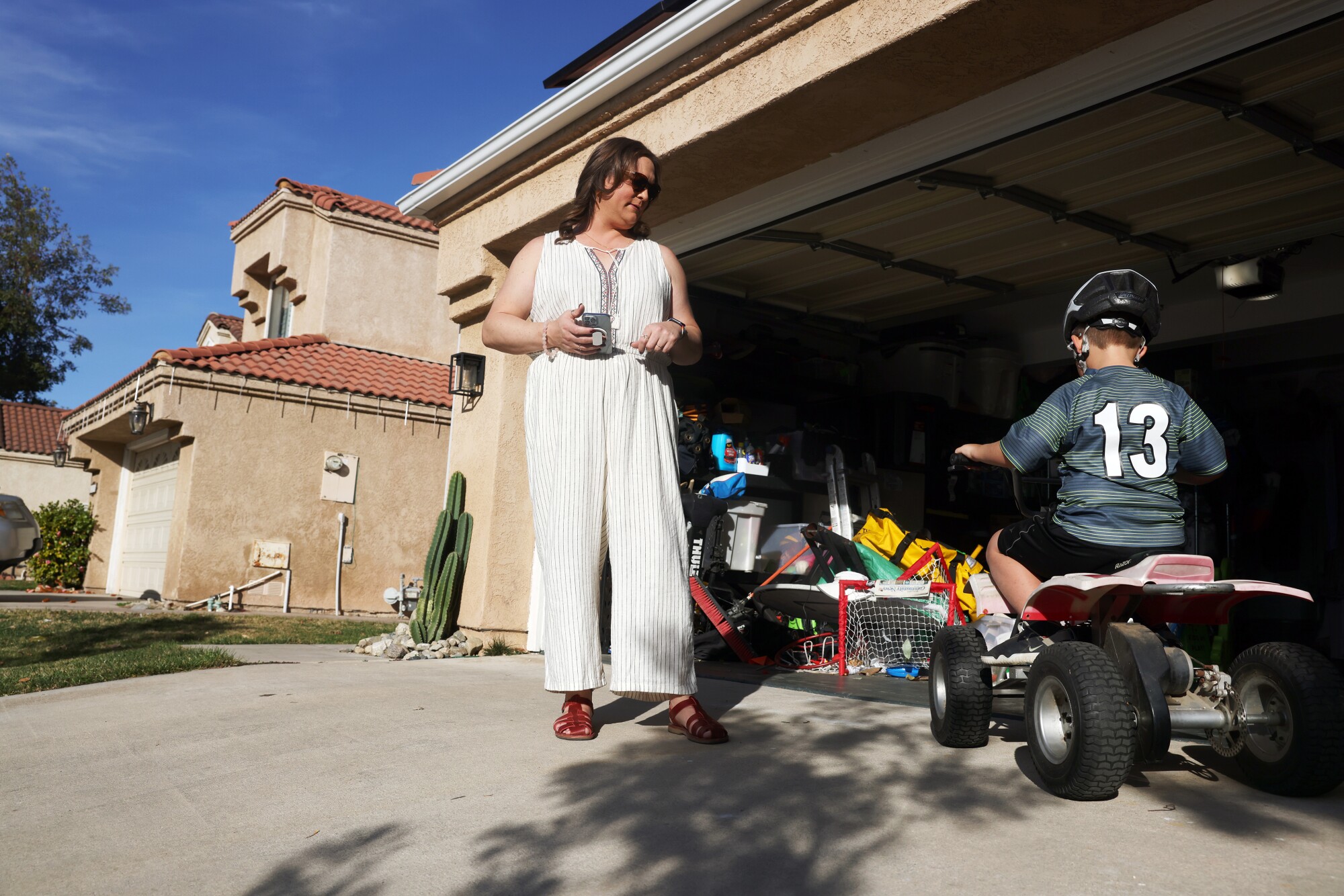 Esther Loewen outside her home while her two boys play