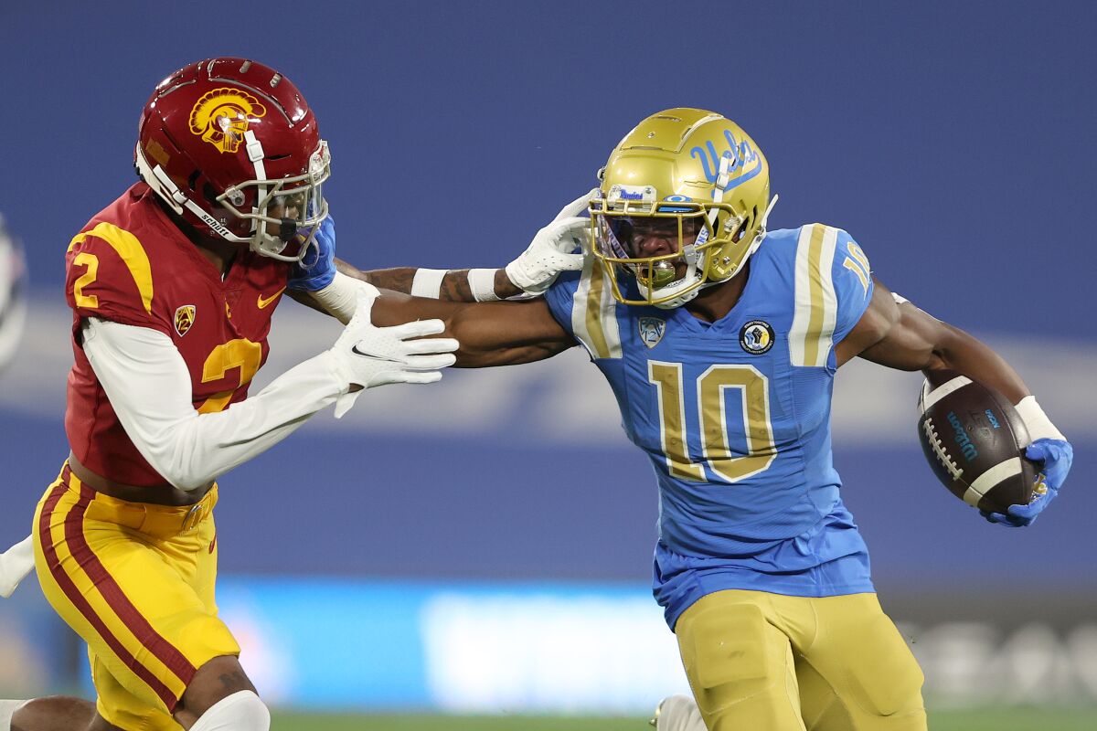 UCLA's Demetric Felton eludes the tackle of USC's Olaijah Griffin.