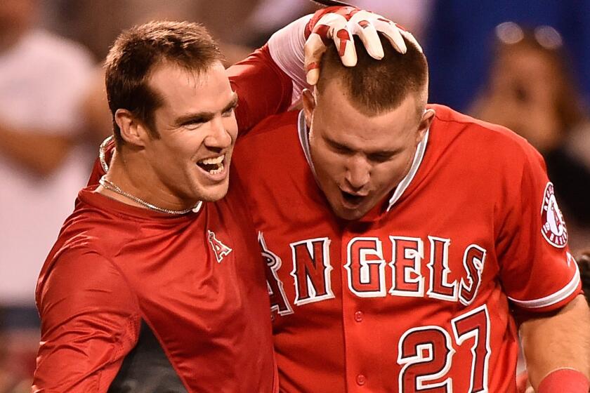 Angels right fielder Collin Cowgill, left, celebrates with teammate Mike Trout after hitting a home run in the 14th inning to lift the Angels to a 2-1 win over the Oakland Athletics on Tuesday.