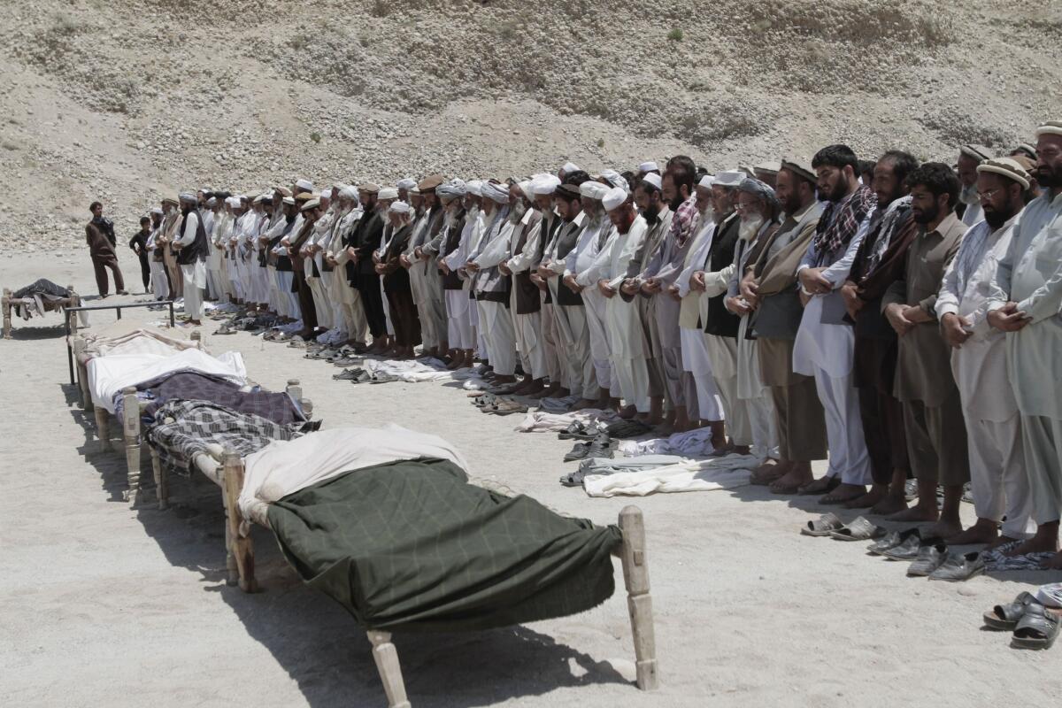 Afghan men offer funeral prayers for seven civilians killed by a roadside bomb in the Alingar district of Laghman province east of Kabul in June.