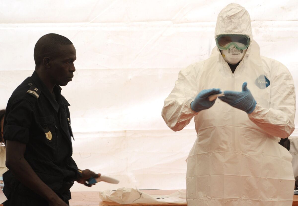 A Senegalese hygienist demonstrates how to protect oneself against the Ebola virus at Dakar airport, during a visit of the Senegalese health minister to check the safety measures put in place.